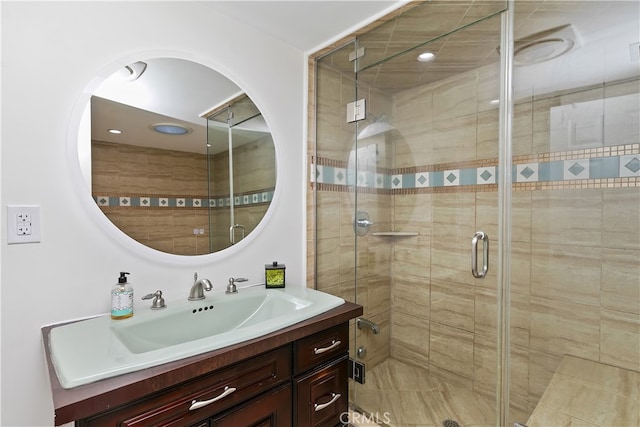 bathroom featuring a shower stall and vanity