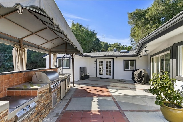 view of patio / terrace with exterior kitchen, french doors, and grilling area