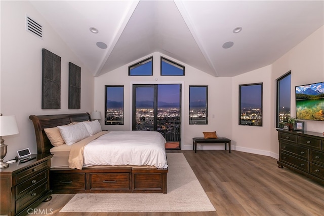 bedroom with lofted ceiling, wood finished floors, visible vents, and baseboards