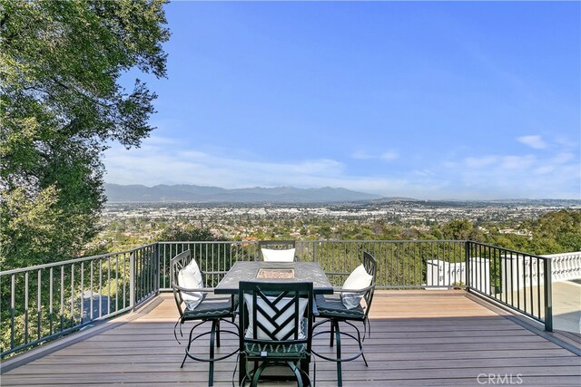 wooden deck featuring outdoor dining area and a mountain view