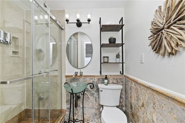 full bath with a stall shower, a wainscoted wall, tile walls, and toilet