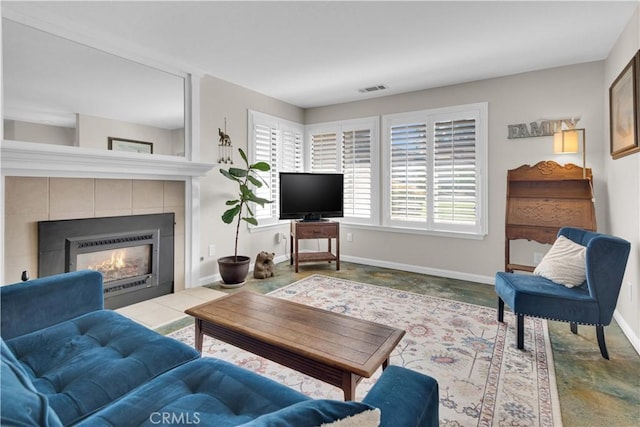 living area featuring baseboards, a fireplace, and visible vents