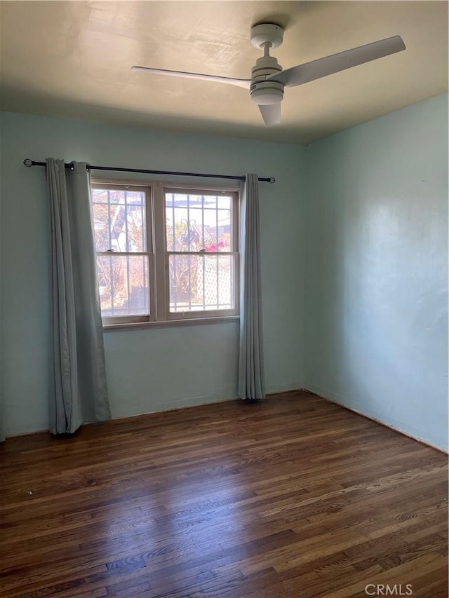 unfurnished room with dark wood-style floors and ceiling fan