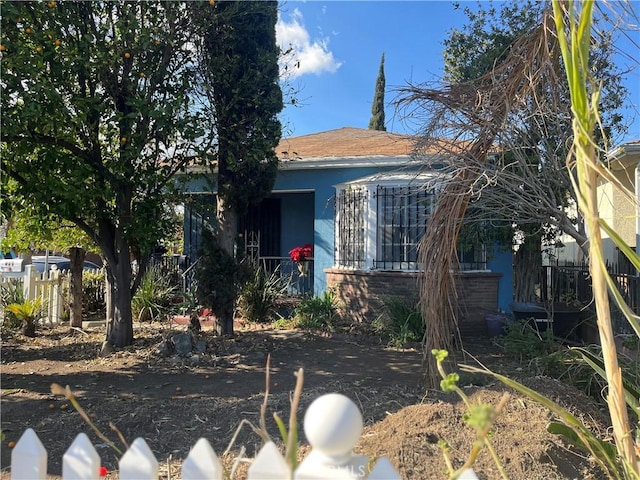 view of front facade featuring fence and stucco siding