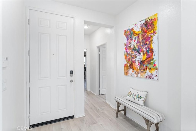 hall featuring light wood finished floors and baseboards