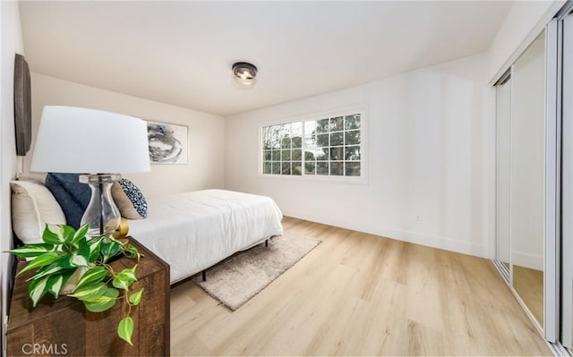 bedroom featuring light wood-style floors and baseboards