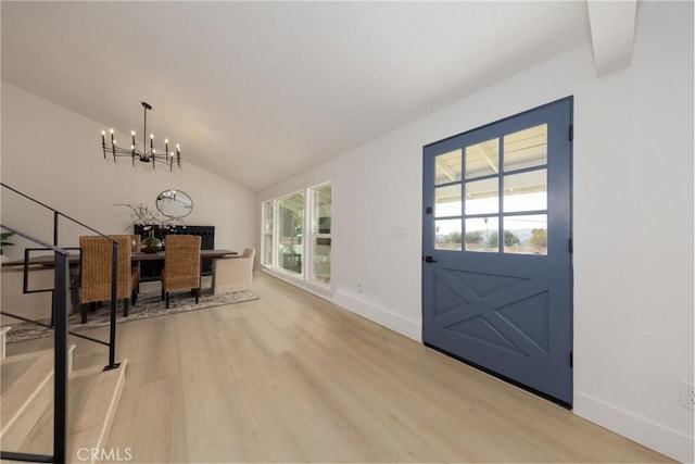 interior space featuring a chandelier, light wood finished floors, vaulted ceiling, and baseboards