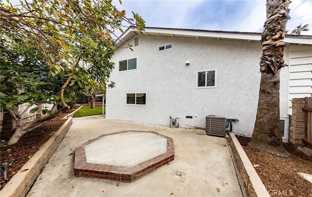 rear view of house featuring central AC, a patio area, fence, and stucco siding