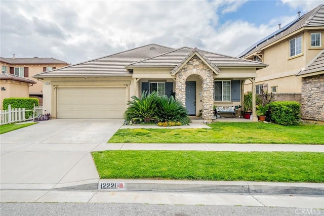 view of front of home featuring a front lawn, fence, a tile roof, concrete driveway, and an attached garage