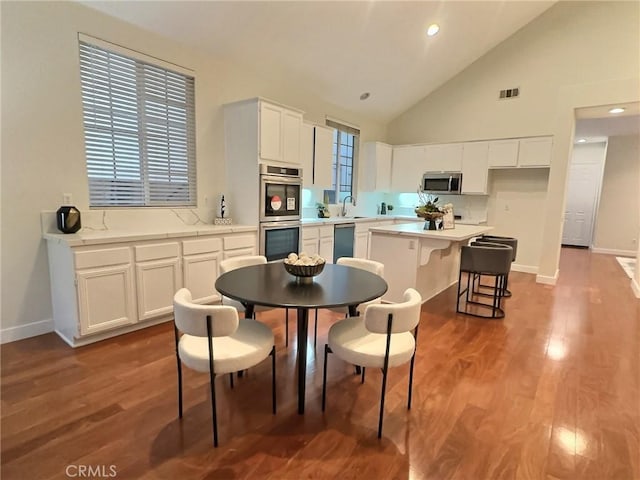 kitchen with visible vents, white cabinets, appliances with stainless steel finishes, and wood finished floors