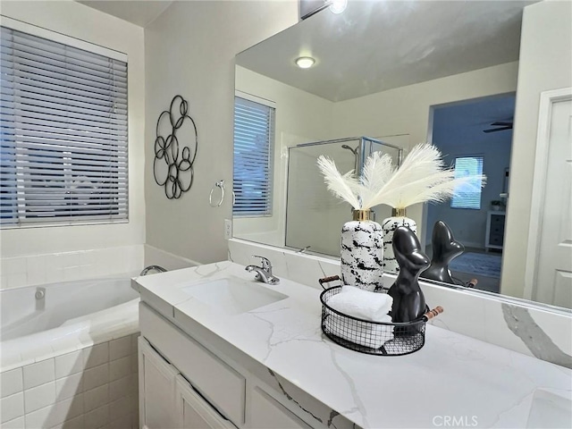 bathroom featuring vanity, a garden tub, and a shower with shower door