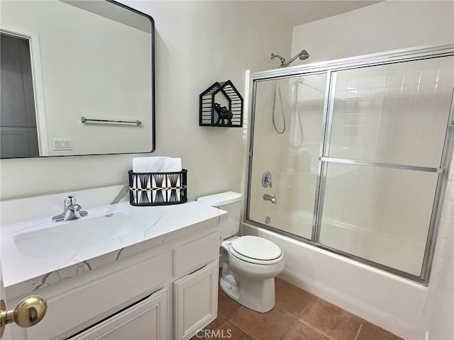 full bathroom featuring tile patterned floors, enclosed tub / shower combo, toilet, and vanity