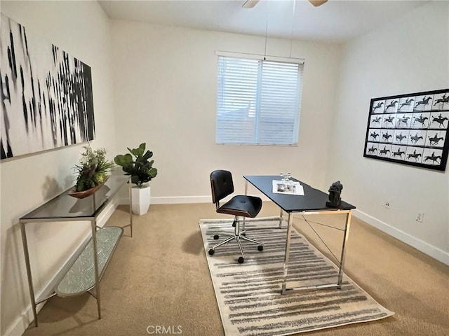 carpeted office space with baseboards and a ceiling fan