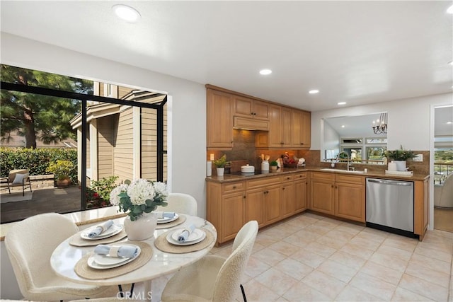 kitchen featuring dishwasher, light countertops, a sink, and brown cabinets