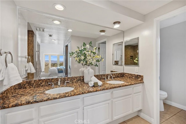 full bath featuring tile patterned flooring, a sink, toilet, and ensuite bathroom