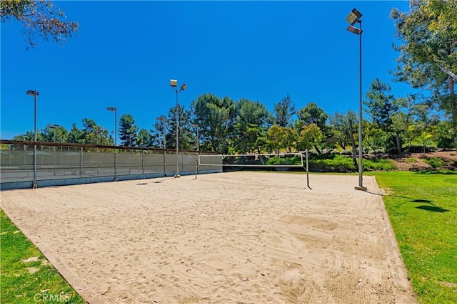 view of home's community featuring volleyball court and fence