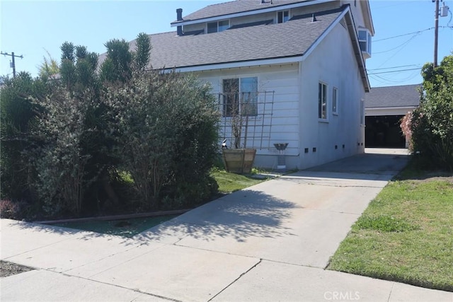 view of home's exterior featuring crawl space, a shingled roof, and a garage