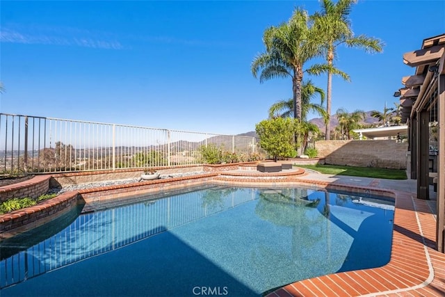 view of pool featuring a fenced in pool, a fenced backyard, a mountain view, and a hot tub