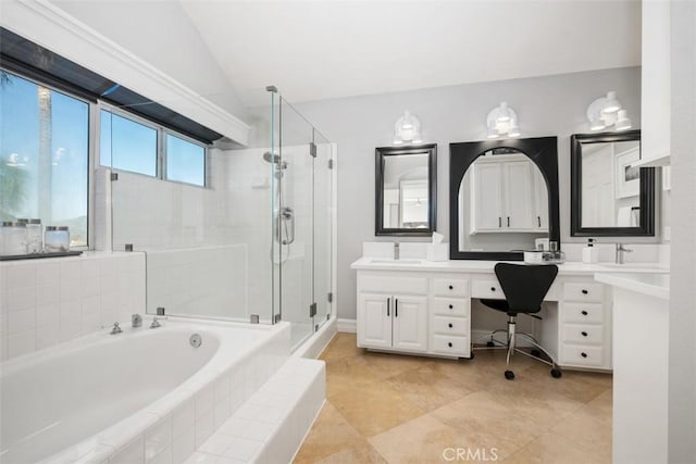 bathroom with a garden tub, a sink, vaulted ceiling, a shower stall, and double vanity