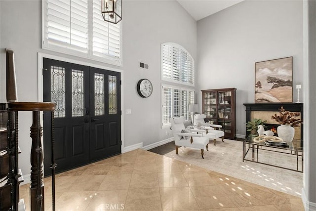 entryway featuring a warm lit fireplace, visible vents, a wealth of natural light, and light tile patterned flooring