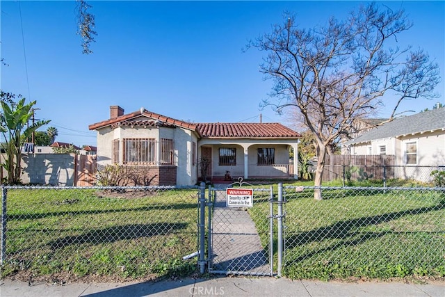 mediterranean / spanish-style home with a tile roof, a chimney, stucco siding, a gate, and fence