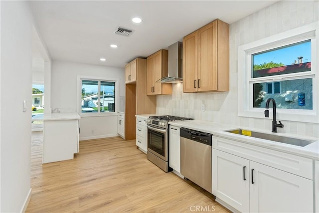 kitchen featuring stainless steel appliances, visible vents, white cabinets, light countertops, and wall chimney exhaust hood