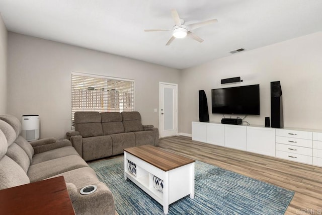 living room featuring visible vents, ceiling fan, and wood finished floors