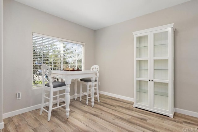 dining room with light wood-type flooring and baseboards