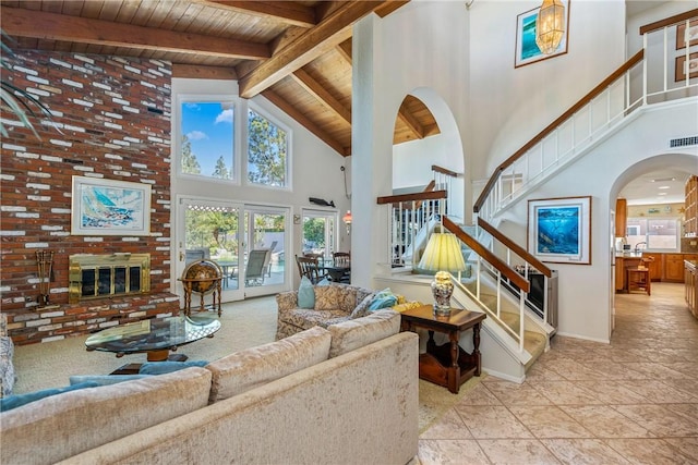 living area with high vaulted ceiling, a fireplace, wood ceiling, stairs, and beamed ceiling