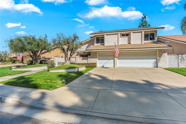 view of front of property featuring an attached garage, fence, driveway, stucco siding, and a front yard