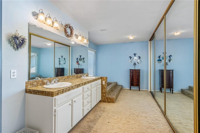 full bath with double vanity, a sink, and visible vents