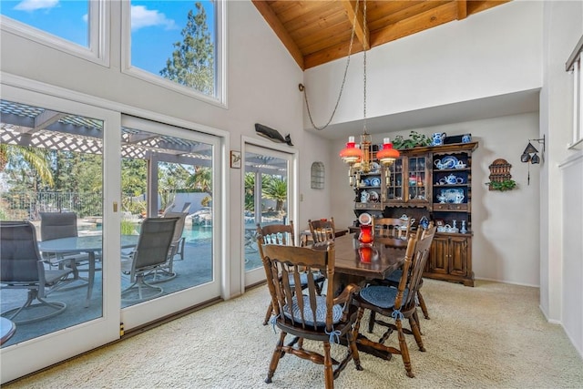 carpeted dining room with high vaulted ceiling and wooden ceiling