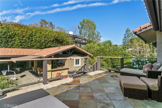 rear view of property featuring a patio area, a tile roof, and stucco siding