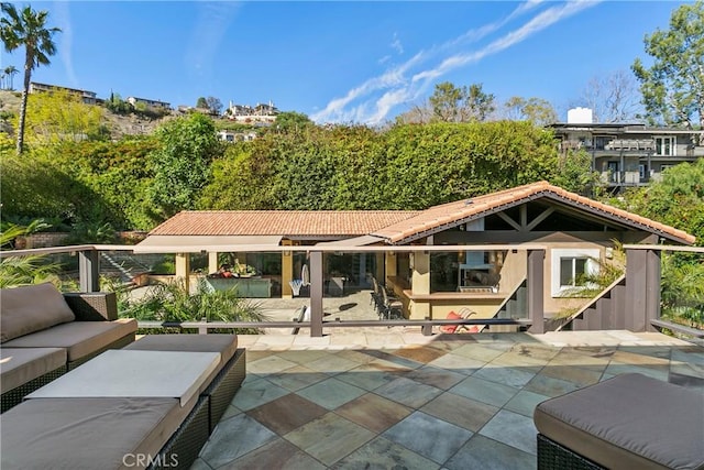 rear view of property featuring an outdoor hangout area, a patio, and a tile roof