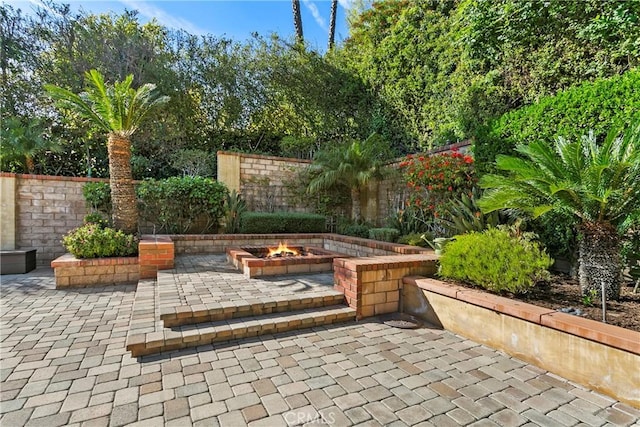 view of patio with a fire pit and fence