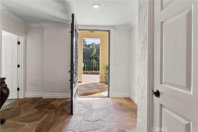 doorway to outside featuring baseboards, stone finish floor, and crown molding