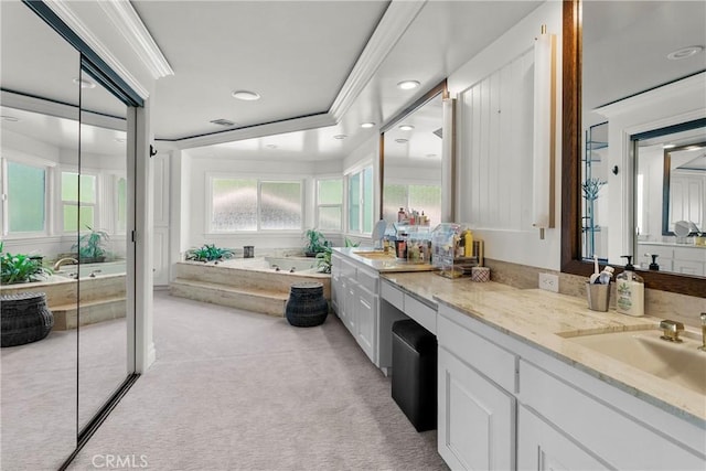 full bath with ornamental molding, vanity, a bath, and a healthy amount of sunlight