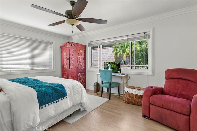 bedroom featuring ornamental molding, light wood-type flooring, and a ceiling fan