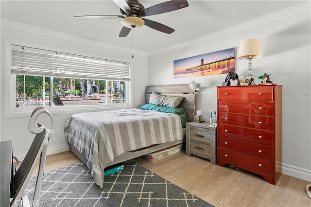 bedroom with baseboards, ceiling fan, ornamental molding, and light wood-style floors