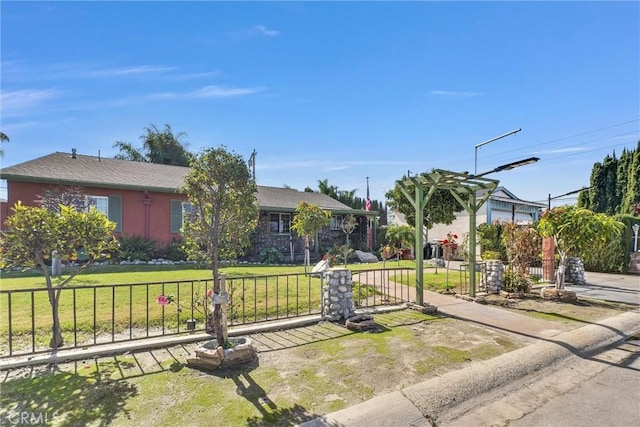 view of front of property featuring a front lawn, fence, and a gate