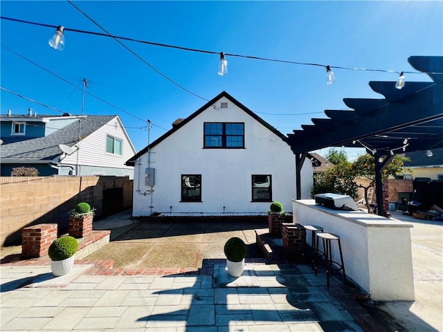 back of house with a patio, outdoor dry bar, a pergola, and fence