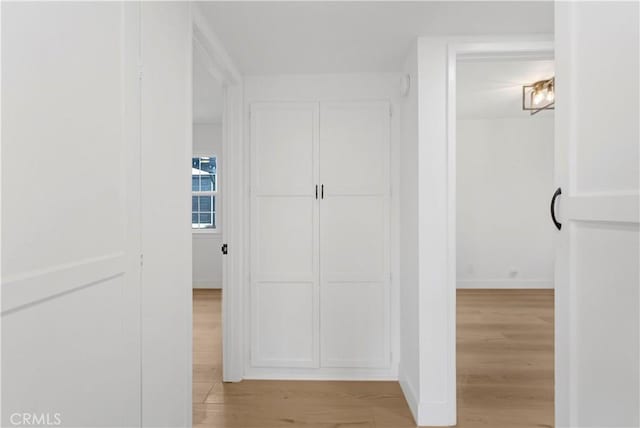 hallway with baseboards and wood finished floors