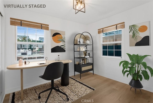 office area with a healthy amount of sunlight, baseboards, and wood finished floors
