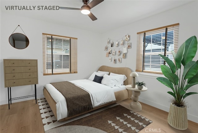 bedroom with a ceiling fan, baseboards, and wood finished floors