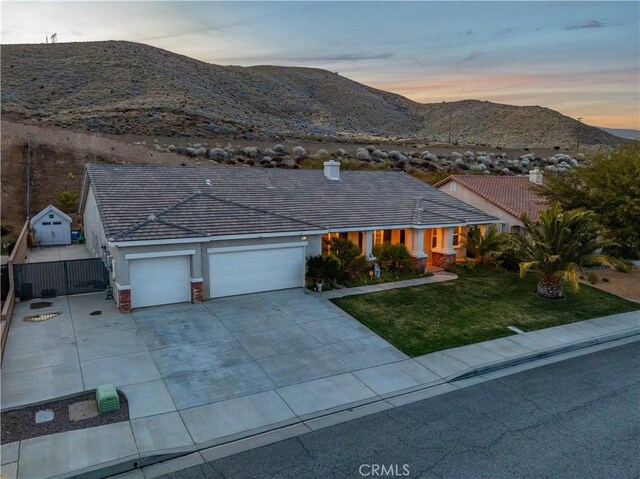 40467 Tiger Way, Palmdale, CA 93551 - view of front of home with a lawn, a garage, fence, a mountain view, and concrete driveway