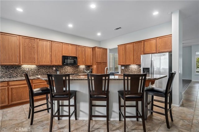 40467 Tiger Way, Palmdale, CA 93551 - kitchen featuring black microwave, tasteful backsplash, brown cabinets, and visible vents