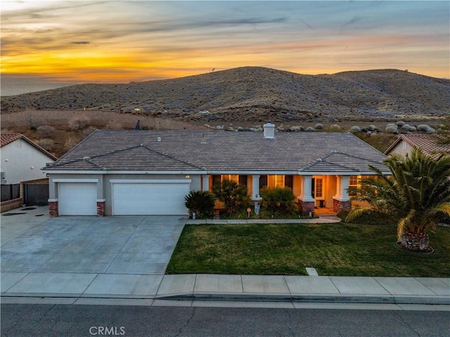 40467 Tiger Way, Palmdale, CA 93551 - view of front of home with a front yard, a garage, fence, a mountain view, and concrete driveway