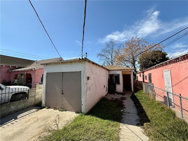 view of property exterior with fence and stucco siding