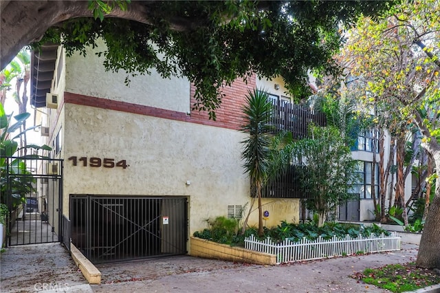 view of building exterior featuring a fenced front yard and an attached garage