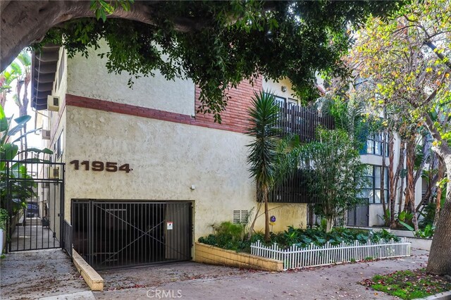 11954 Goshen Ave Unit 205, Los Angeles, CA 90049 - view of side of home with stucco siding, a gate, and fence